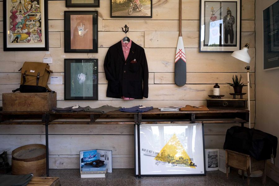 Plank wall with framed prints above a shelf table and floor-standing frame