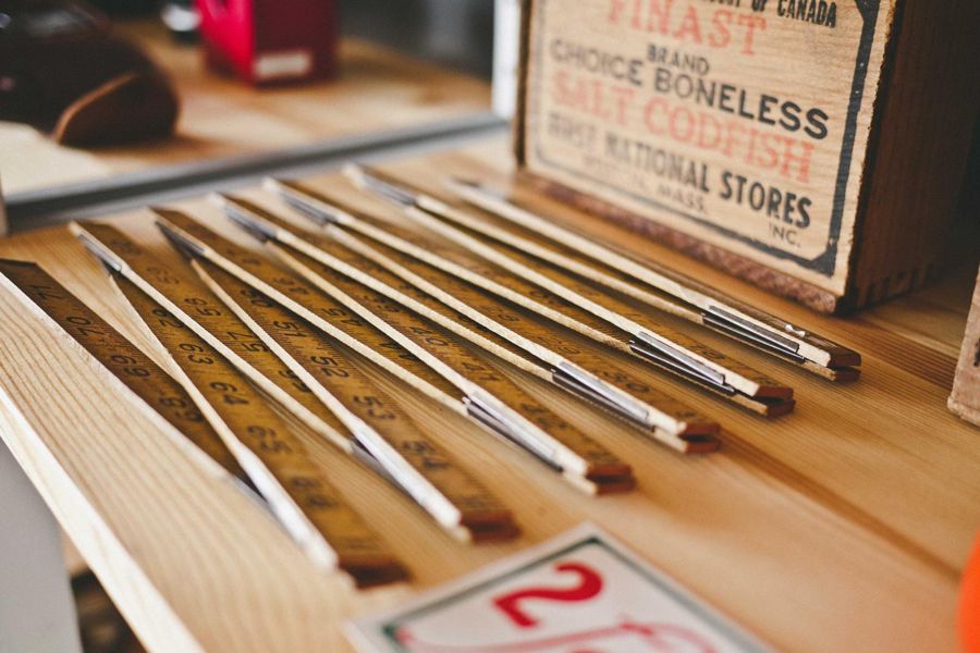 Folding wooden rules fanned out on a pine shelf
